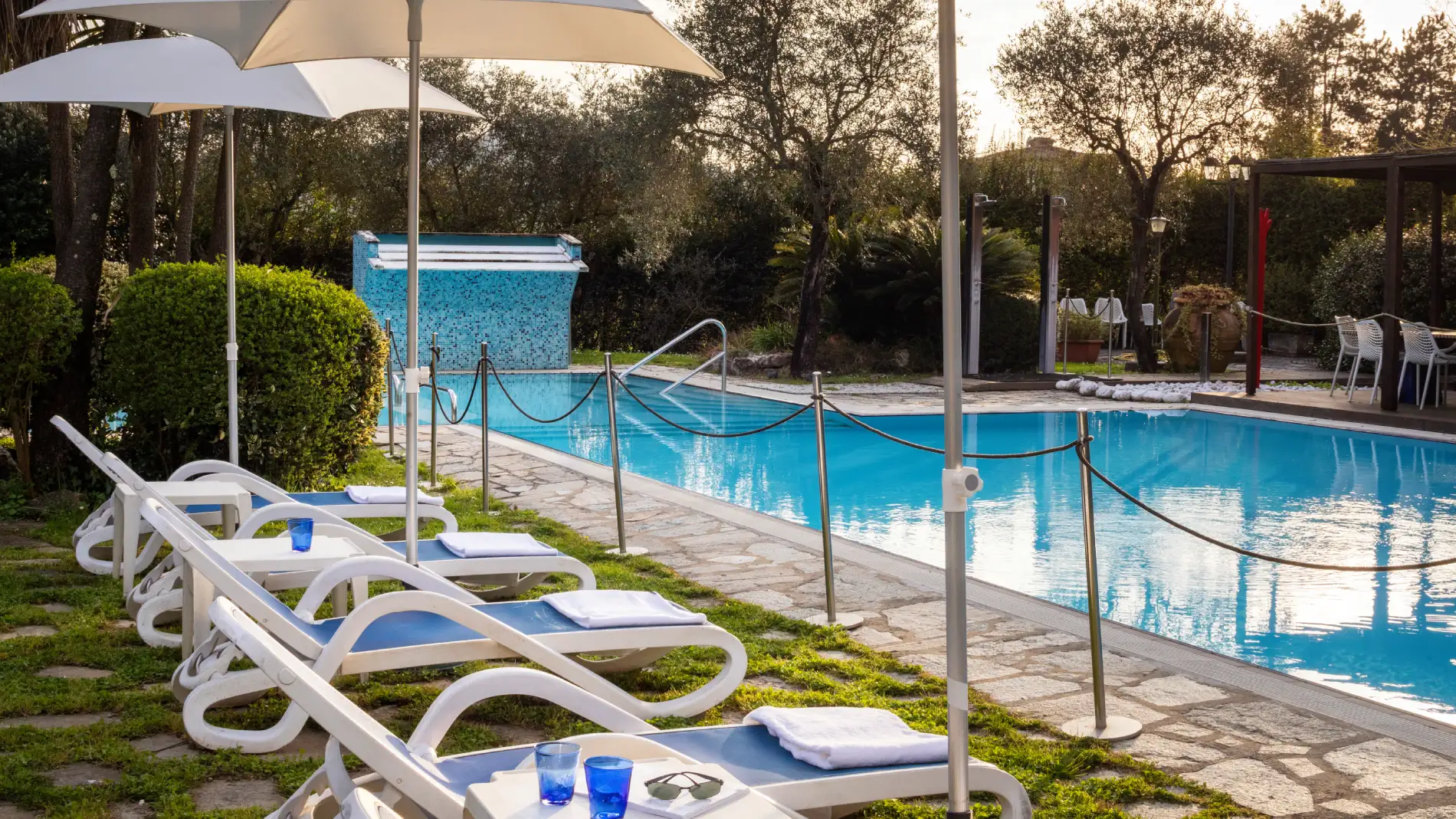 Piscina esterna immersa nel verde con lettini e ombrelloni per relax all’aperto in Liguria - Sarzana Park Hotel, BZAR hotels in Liguria