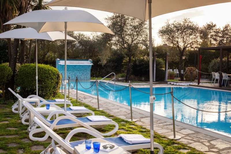 Zona solarium con lettini e ombrelloni a bordo piscina per momenti di benessere in Liguria - Sarzana Park Hotel, BZAR hotels in Liguria